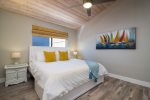 The East main bedroom features a king size bed, a ceiling fan and a flatscreen TV